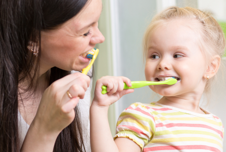 Close up of Child and Mother brushing teeth - The Super Dentists
